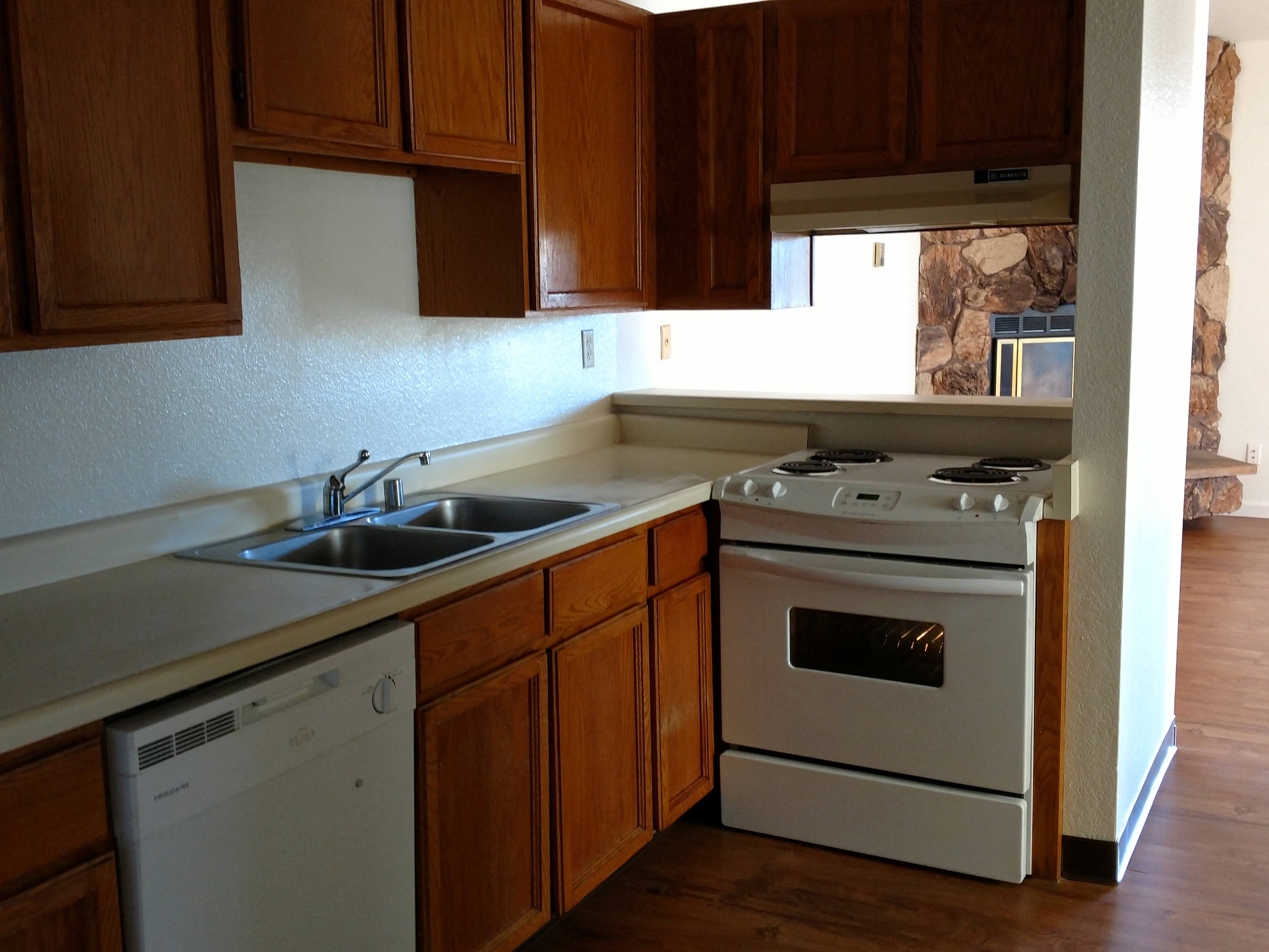 a kitchen with white appliances and wooden cabinets